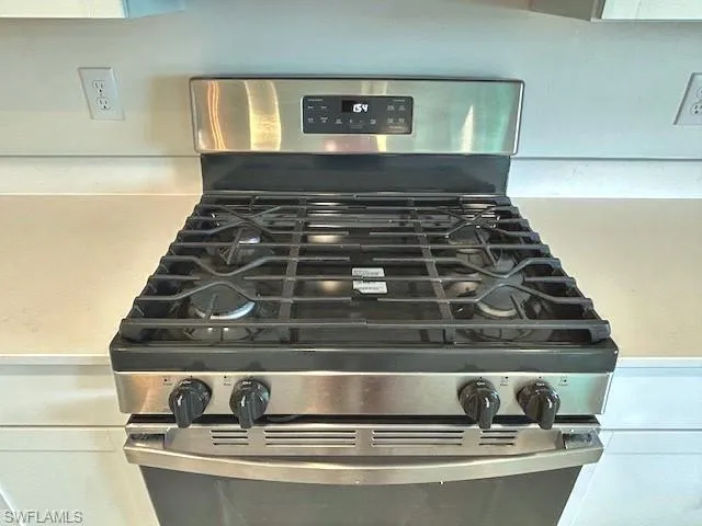 Details with white cabinetry and stainless steel range with gas stovetop