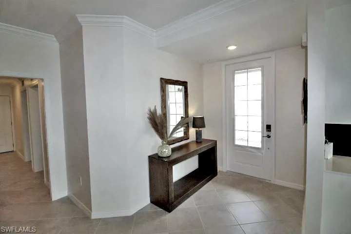 Tiled entrance foyer featuring ornamental molding throughout and freshly painted.