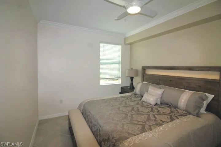 Bedroom 2 w/ceiling fan, blinds and tile flooring.