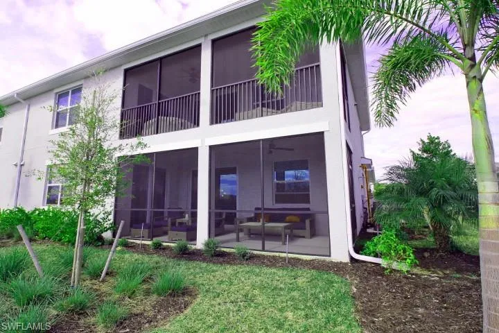 Rearview of property featuring a yard and lush landscaping.