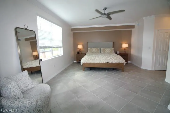 Bedroom featuring ornamental molding, light tile flooring and ceiling fan