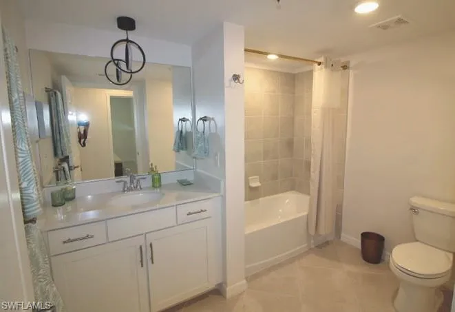 Full bathroom with tile floors, vanity, toilet, and shower / tub combo