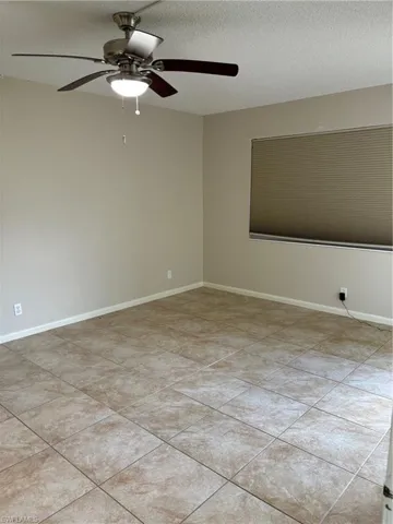 Tiled bedroom with a textured ceiling and ceiling fan
