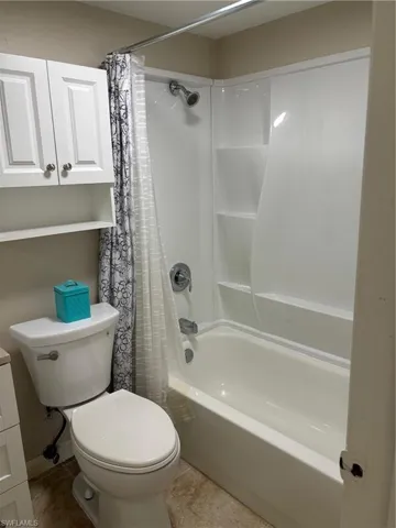 Bathroom with tile patterned flooring, toilet, and shower / tub combo