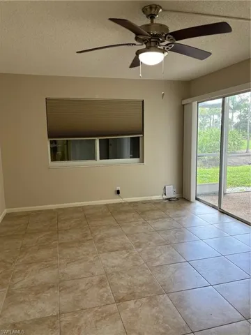 Tiled master bedroom with ceiling fan and a textured ceiling