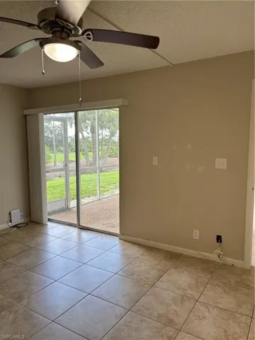 Master bedroom room with ceiling fan and light tile patterned floors and sliding Glass patio Doors