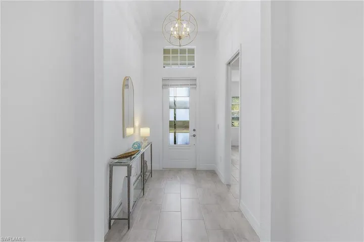 Entrance foyer featuring an inviting chandelier and ornamental molding