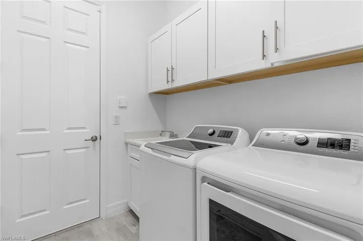 Laundry area featuring cabinets, sink, and washer and clothes dryer