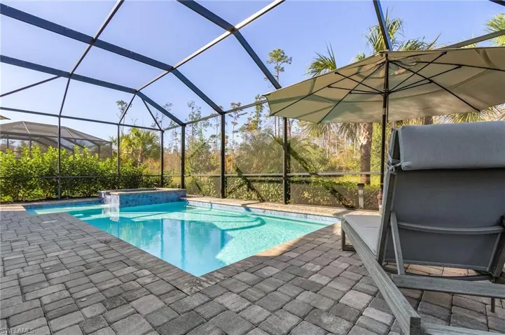 View of swimming pool featuring a patio, a lanai, and an in ground hot tub
