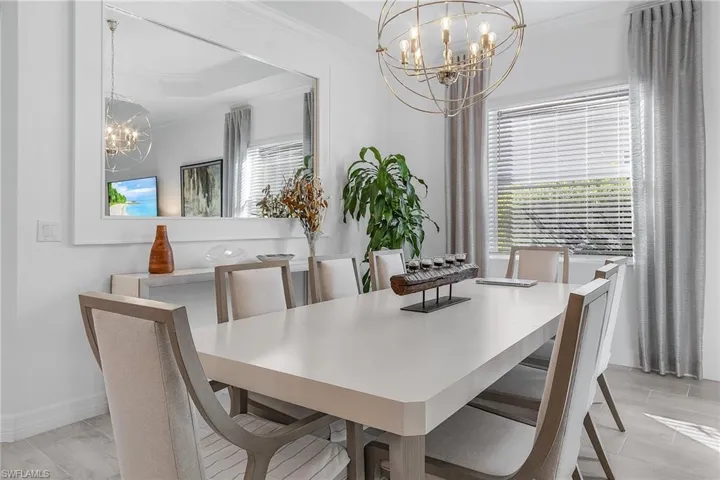 Dining space featuring a notable chandelier and crown molding