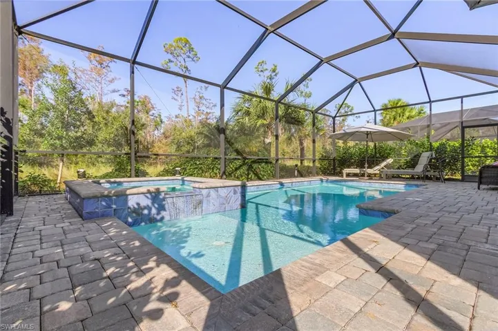 View of pool with a patio, a lanai, and a spa
