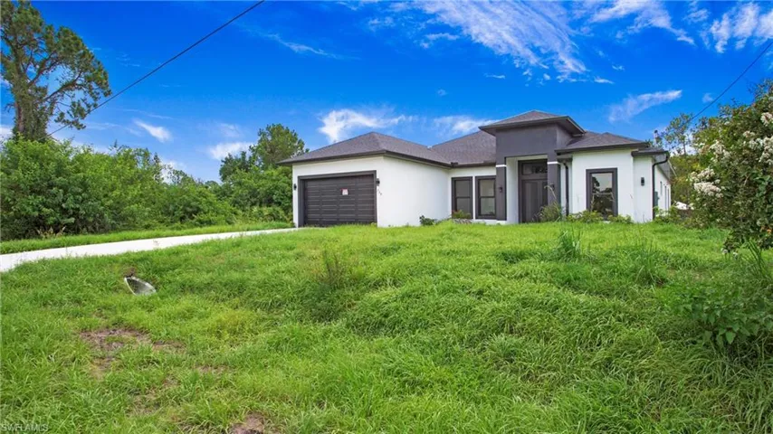 View of front of home featuring stucco siding and an attached garage
