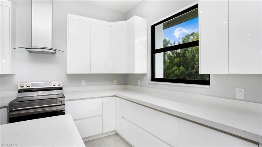 Kitchen featuring stainless steel electric stove, island exhaust hood, and modern cabinets