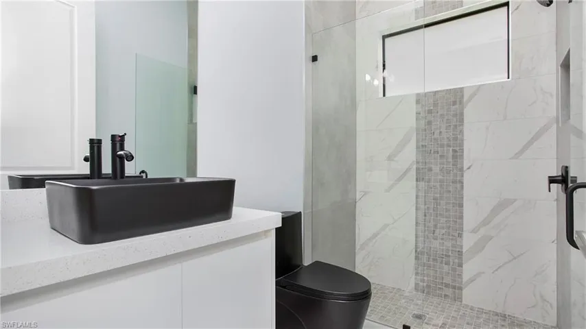 Full bathroom featuring tiled shower and vanity