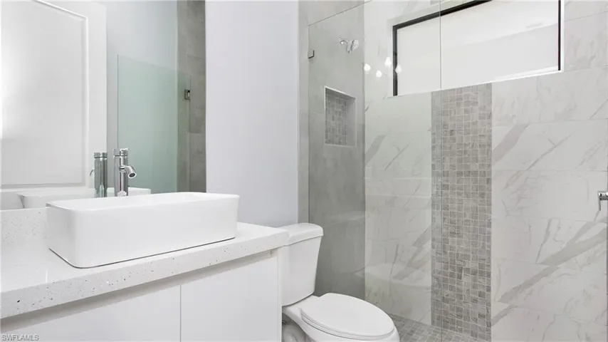 Full bath featuring vanity and a tile shower