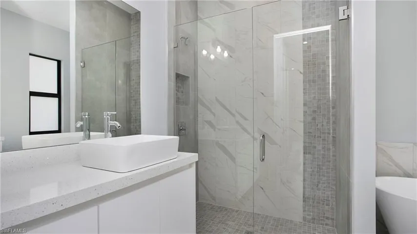 Full bathroom with a stall shower, vanity, and a soaking tub