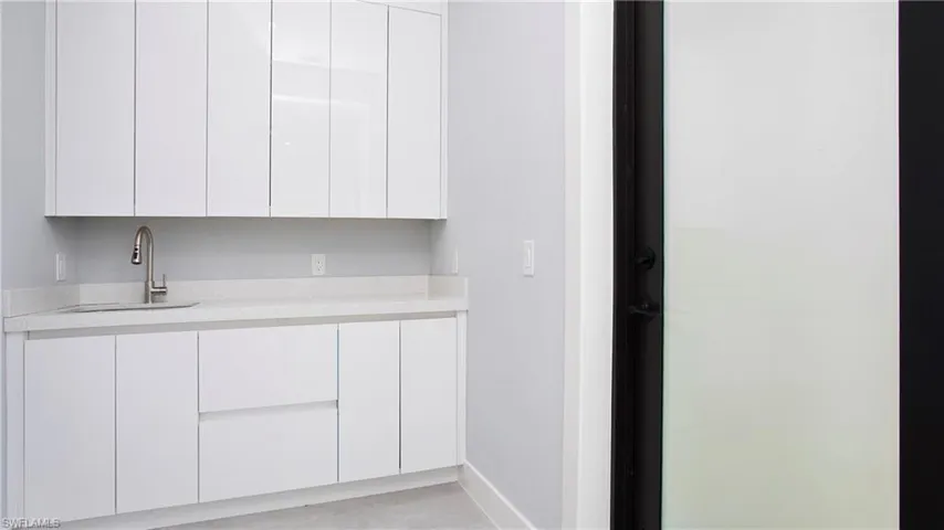 Kitchen with modern cabinets, light countertops, and white cabinetry