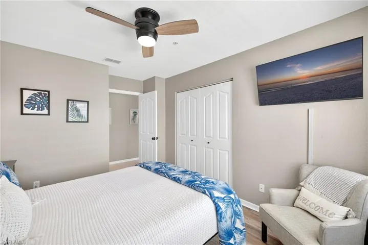 Bedroom with ceiling fan, wood finished floors, and a closet