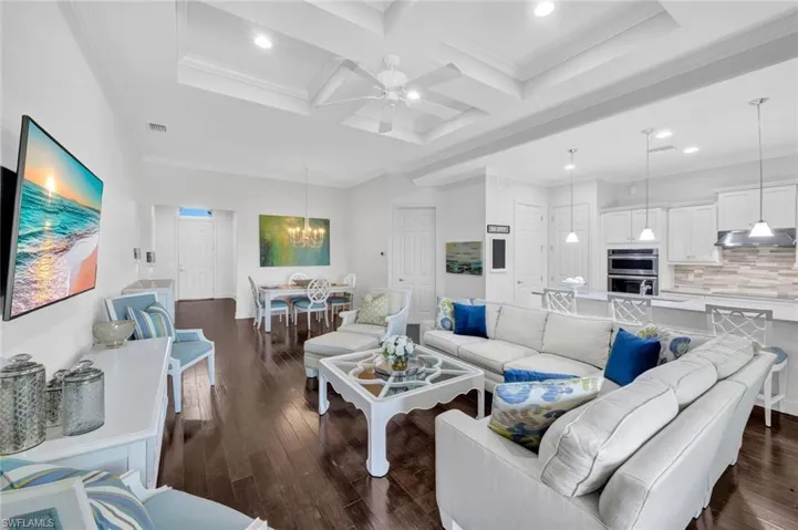 Family room with hardward floors, custom ceiling, access to dining room and open concept kitchen.