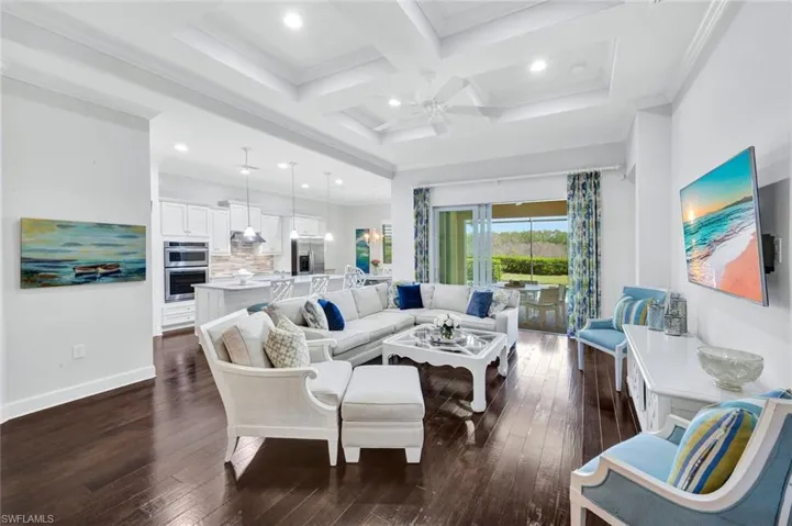 Great room with hardwood floors, family room, open concept kitchen, breakfast nook and access to the outdoor lanai with pool and spa via sliding glass doors.