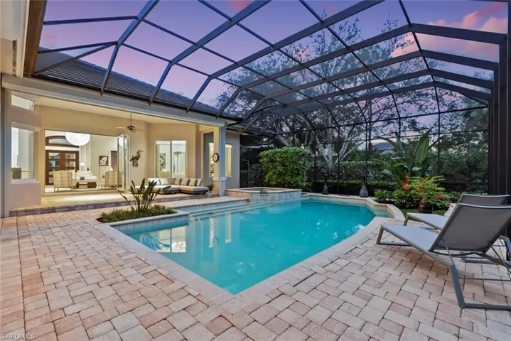 View of swimming pool featuring an outdoor hangout area, a patio area, a pool with connected hot tub, ceiling fan, and glass enclosure