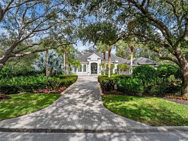 View of front facade with stucco siding, french doors, and a front yard