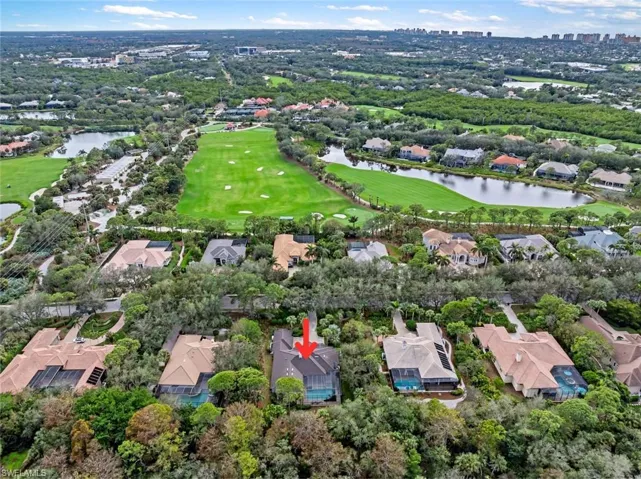 Aerial view of property's location featuring a large body of water, nearby suburban area, and a local golf course