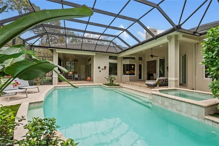 View of swimming pool featuring a ceiling fan, a patio area, and glass enclosure