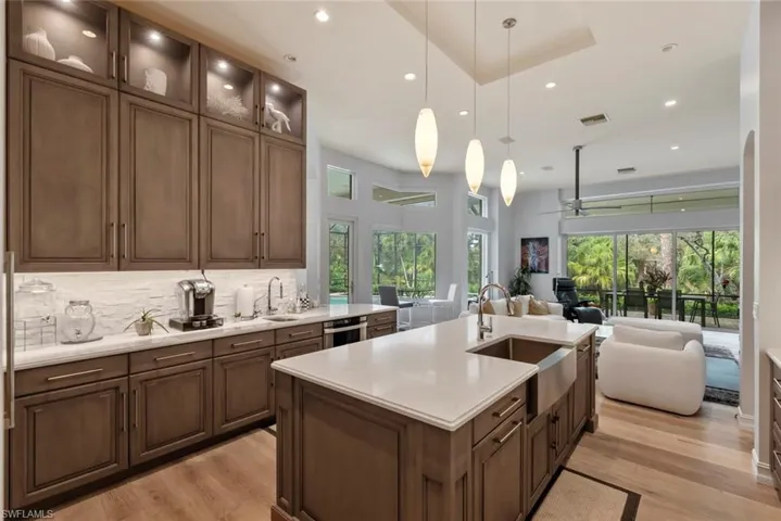 Kitchen featuring a sink, open floor plan, light wood-style flooring, light countertops, and recessed lighting