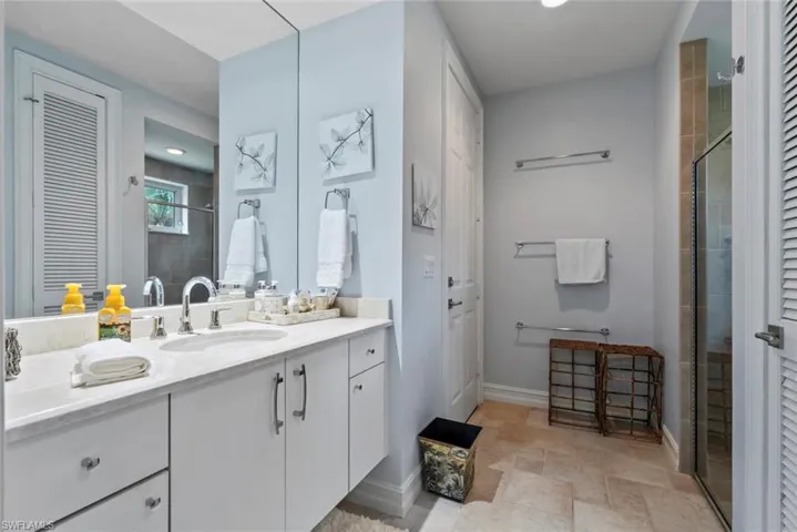 Bathroom with vanity, a shower stall, and a closet