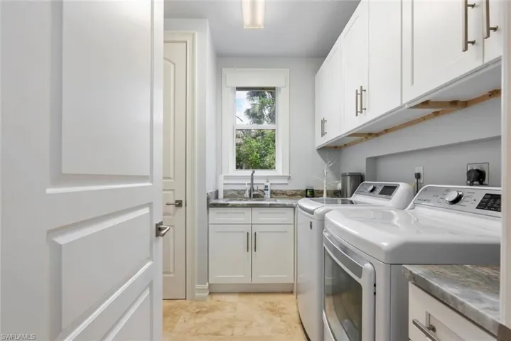 Laundry room with washer and clothes dryer and cabinet space
