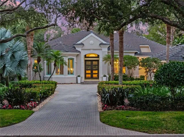View of front facade featuring french doors, a tiled roof, and stucco siding