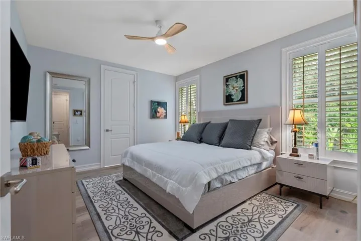 Bedroom featuring light wood-type flooring, a ceiling fan, and baseboards