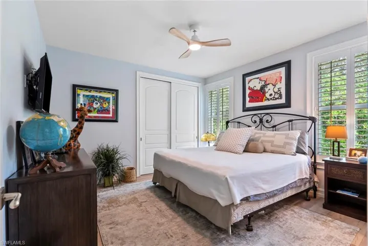 Bedroom with a closet, wood finished floors, and a ceiling fan