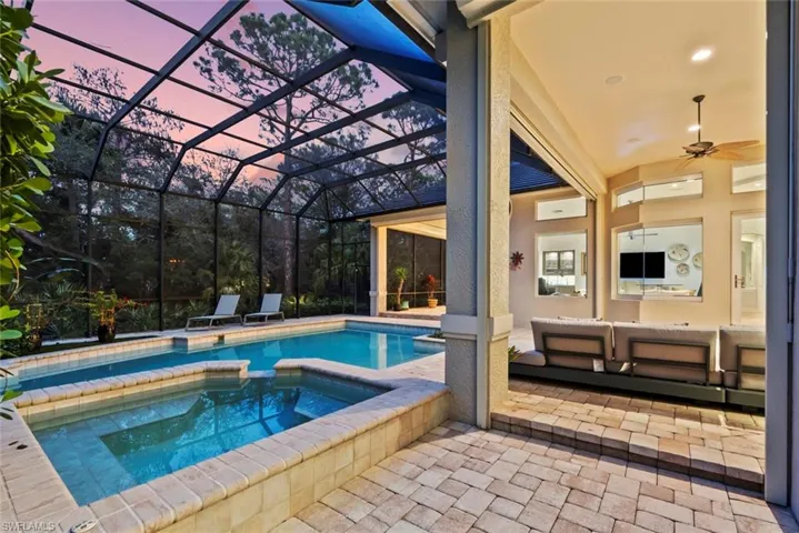 View of pool featuring a patio area, a lanai, and a pool with connected hot tub