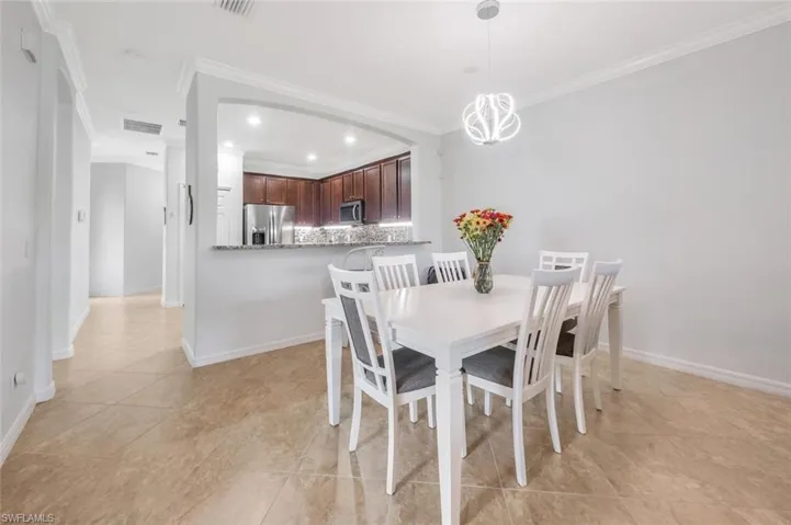 Tiled dining area featuring crown molding