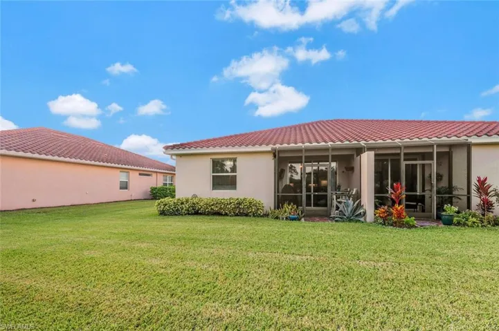 Rear view of house with a sunroom and a yard