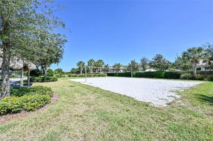 View of property's community featuring volleyball court and a lawn