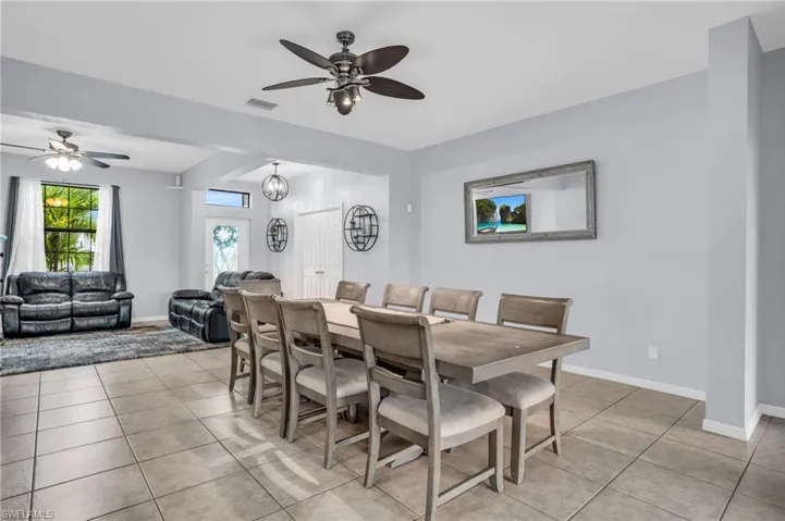 Dining space with ceiling fan and light tile floors