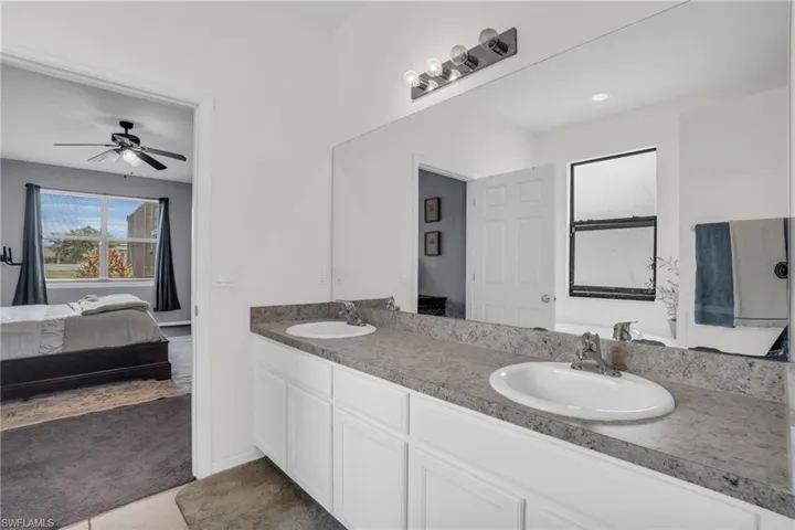 Bathroom with dual bowl vanity and ceiling fan