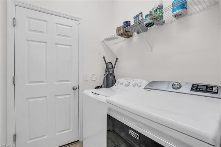 Laundry area featuring tile floors and washing machine and clothes dryer