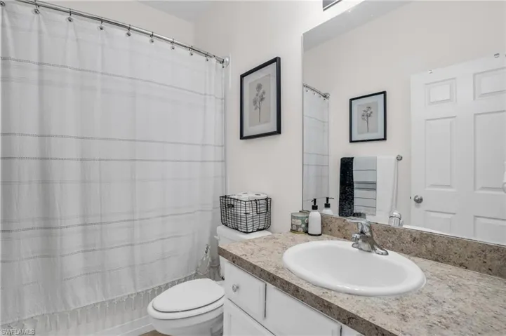 Bathroom featuring large vanity and toilet