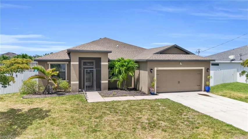 View of front of property featuring a front lawn and a garage