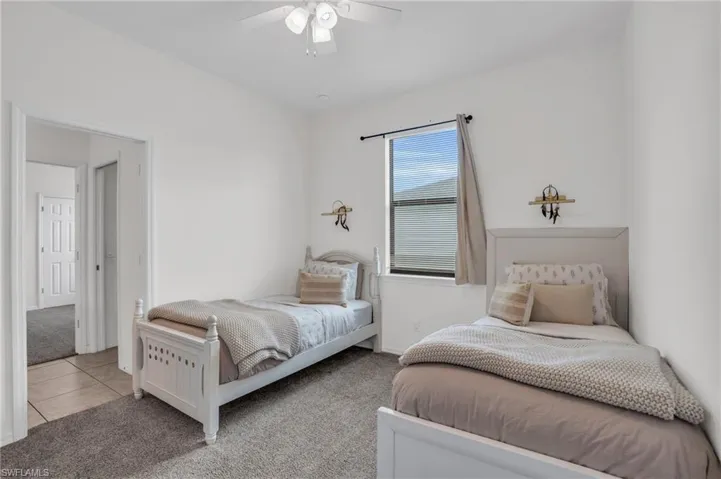Tiled bedroom featuring ceiling fan