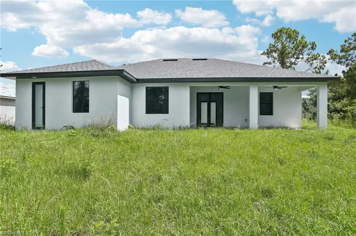 Back of house featuring a yard and ceiling fan