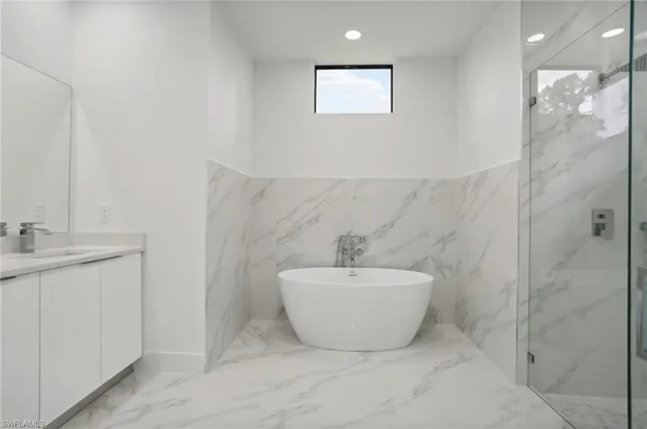 Bathroom with tile walls, tile floors, plus walk in shower, and vanity