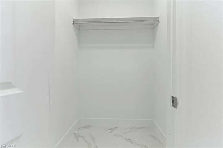 Walk in closet with tile flooring