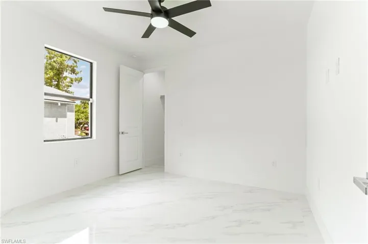 Tiled empty room featuring ceiling fan