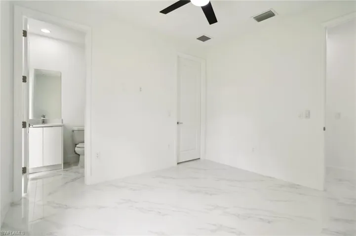 Tiled empty room featuring ceiling fan