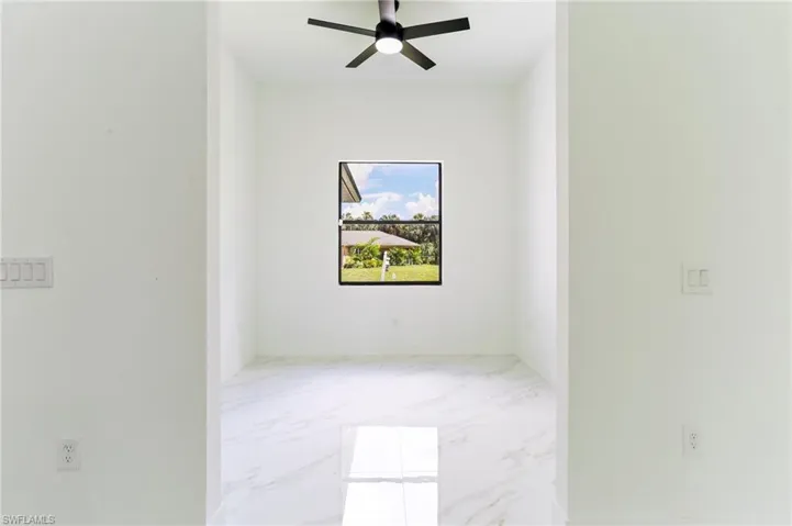 Tiled spare room with ceiling fan